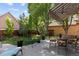 A peaceful backyard featuring mature trees, well-maintained lawn, and a cozy patio setting with comfortable seating at 652 Ulster Way, Denver, CO 80230