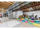 Unfinished basement with exposed ceiling and colorful flooring, ready for customization at 652 Ulster Way, Denver, CO 80230