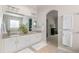 Bright bathroom features a double vanity with granite countertop and walk-in tub at 652 Ulster Way, Denver, CO 80230