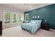 Bedroom featuring windows, a teal accent wall, and a comfortable bed at 652 Ulster Way, Denver, CO 80230
