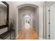 Hallway featuring archways and wood floors leading to an office and the front entrance at 652 Ulster Way, Denver, CO 80230
