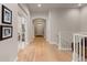 Hallway view with wood floors, archway and neutral walls leading to the front door at 652 Ulster Way, Denver, CO 80230