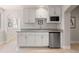 Modern kitchenette with white cabinets, granite countertops, and stainless steel appliances at 652 Ulster Way, Denver, CO 80230