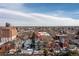 Expansive aerial view of home showing the surrounding neighborhood with mature trees and city skyline in the distance at 1435 Vine St # 2, Denver, CO 80206