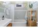 Bright bathroom features classic tiling, tub with shower, vintage sink and modern shelving at 1435 Vine St # 2, Denver, CO 80206