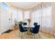 Charming dining area featuring a round glass table, blue chairs, and bright natural light from the windows at 1435 Vine St # 2, Denver, CO 80206