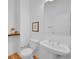 Cozy half-bathroom with pedestal sink, framed art, and hardwood flooring at 2680 Blake St # 13, Denver, CO 80205