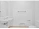Minimalist bathroom featuring a pedestal sink, toilet, and towel rack against a white backdrop at 2680 Blake St # 13, Denver, CO 80205