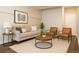 Neutral living room featuring a sofa, wood-topped coffee table, and two arm chairs at 5555 E Briarwood Ave # 706, Centennial, CO 80122