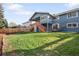Large backyard with green lawn, wood fence, deck with stairs, and potential for outdoor living at 10795 E Powers Dr, Englewood, CO 80111