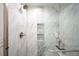Modern shower with stylish tile, niche, and a glass door at 10795 E Powers Dr, Englewood, CO 80111
