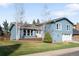 Charming two-story home with blue siding, attached garage, and well-maintained front yard at 10795 E Powers Dr, Englewood, CO 80111