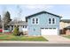 Charming blue two-story home with a well-maintained front yard and attached two-car garage at 10795 E Powers Dr, Englewood, CO 80111