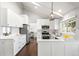 Bright kitchen featuring white cabinets, stainless steel appliances, and hardwood floors at 10795 E Powers Dr, Englewood, CO 80111