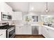 Modern kitchen with white cabinetry, stainless steel appliances, and subway tile backsplash at 10795 E Powers Dr, Englewood, CO 80111