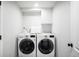 Efficient laundry room equipped with modern washer and dryer units and practical storage solutions at 10795 E Powers Dr, Englewood, CO 80111