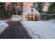 Snow covered driveway leads to a charming white house with porch at 950 Tenderfoot Dr, Larkspur, CO 80118