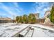 Spacious backyard featuring a brick fire pit, wooden fence, and large patio space covered in snow at 19731 E 40Th Ave, Denver, CO 80249