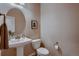 Charming powder room featuring a pedestal sink, decorative mirror, and elegant fixtures for guests' convenience at 2618 S Kilmer Ct, Denver, CO 80228