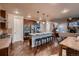 Open-concept kitchen with island seating, stainless steel appliances, and seamless flow to living area and fireplace at 2618 S Kilmer Ct, Denver, CO 80228