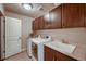Well-organized laundry room equipped with modern washer and dryer, cabinets, and a utility sink at 2618 S Kilmer Ct, Denver, CO 80228