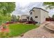 Green backyard featuring a patio, deck, retaining wall, and wooden fence at 21486 E Crestline Ln, Centennial, CO 80015