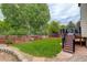 Green backyard featuring a deck, wooden fence, and retaining wall at 21486 E Crestline Ln, Centennial, CO 80015