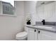 Stylish powder room with a modern vanity, round mirror, and attractive wall paneling at 21486 E Crestline Ln, Centennial, CO 80015