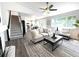 Bright living room featuring neutral decor, plush sofa, and access to the kitchen and staircase at 21486 E Crestline Ln, Centennial, CO 80015