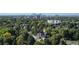 An aerial view of the tree-lined neighborhood with the city skyline in the background on a clear, bright day at 718 Locust St, Denver, CO 80220