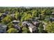 An aerial view of the home nestled among lush trees with the city skyline in the background on a bright sunny day at 718 Locust St, Denver, CO 80220