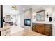 Bright bathroom with fireplace, dual vanities, modern soaking tub, and hardwood floors at 718 Locust St, Denver, CO 80220
