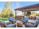 Entertain in style with an outdoor kitchen, bar, seating area, and fire pit with comfortable seating at 17294 W 60Th Ct, Arvada, CO 80403