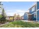 The large backyard has a well-kept lawn, stone patio, mature trees, and outdoor seating areas at 17294 W 60Th Ct, Arvada, CO 80403