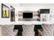 Basement bar area with a large countertop and stylish seating at 17294 W 60Th Ct, Arvada, CO 80403