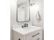 Bathroom vanity featuring white marble countertop, black faucet, sleek drawers, and modern black framed mirror at 17294 W 60Th Ct, Arvada, CO 80403