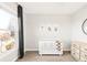 Bright bedroom with a crib, dresser, and a large window at 17294 W 60Th Ct, Arvada, CO 80403