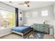 Well-lit bedroom featuring a large window and a sleek blue dresser at 17294 W 60Th Ct, Arvada, CO 80403