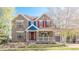 Charming two-story home featuring a lovely front porch, brick facade, and colorful details at 17294 W 60Th Ct, Arvada, CO 80403