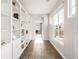 Hallway with built-in bookshelves, tiled floor, natural light and views of the exterior at 17294 W 60Th Ct, Arvada, CO 80403