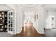 Bright hallway featuring hardwood floors, white walls, and stylish architectural details at 17294 W 60Th Ct, Arvada, CO 80403