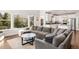 Cozy living room with large windows offering natural light and an open connection to the kitchen at 17294 W 60Th Ct, Arvada, CO 80403