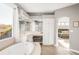 Spa-like main bathroom features a soaking tub, vanity with makeup area, and arched doorway at 17294 W 60Th Ct, Arvada, CO 80403