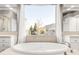 Bright bathroom with a large soaking tub, double vanity, and a picturesque view of the outdoors at 17294 W 60Th Ct, Arvada, CO 80403