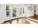 Bright sunroom featuring hardwood floors and large windows showcasing the backyard patio at 17294 W 60Th Ct, Arvada, CO 80403