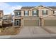 Townhome with a two-car garage and stone facade detailing at 5689 Raleigh Cir, Castle Rock, CO 80104