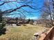 Large backyard with a playground, shed, mature trees, and wooden fence at 2418 W Euclid Ave, Littleton, CO 80120