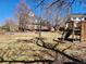 Large backyard with a playground, stone wall, patio, and mature trees at 2418 W Euclid Ave, Littleton, CO 80120