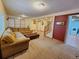 Open basement featuring carpet flooring, a large sectional, and a partial view of the laundry room at 2418 W Euclid Ave, Littleton, CO 80120