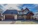 Charming two-story home featuring stone accents, a two-car garage, and a welcoming covered front porch at 2418 W Euclid Ave, Littleton, CO 80120